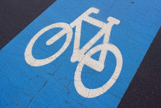 Weathered blue urban bicycle lane with space for text.
