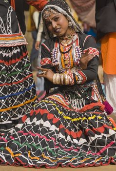 Female kalbelia dancer in traditional tribal dress performing at the annual Sarujkund Fair near Delhi, India