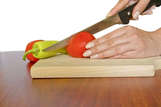 Cutting tomato on wooden board