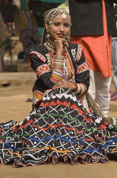 Rajasthani dancer in ornate black costume trimmed with beads and sequins performing at the Sarujkund Fair near Delhi in India.