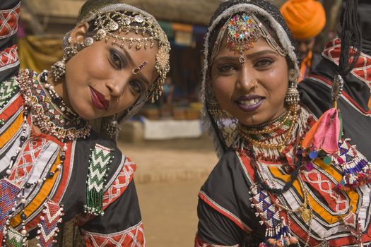 Beautiful Kalbelia dancers in ornate black costumes trimmed with beads and sequins at the annual Sarujkund Fair near Delhi, India.