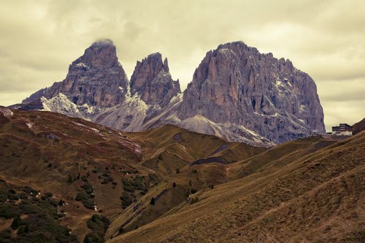 September morning with low hanging clouds in the Dolomites. The Pass of Sella to the right.  Image is cross processed and a little film grain added to reflect age.