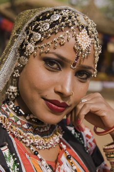 Beautiful Kalbelia dancer in ornate black costume trimmed with beads and sequins at the Sarujkund Fair near Delhi in India.
