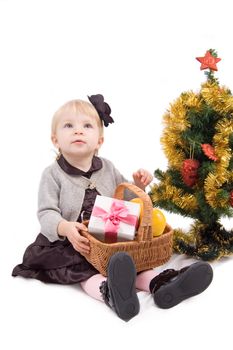 Little girl with Christmas tree and giftsover white