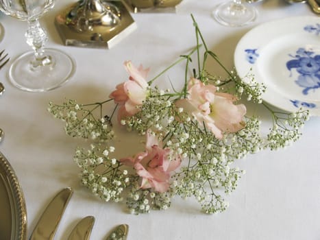 A beautiful laid dinnertable in retro style with very old silver, glasses and porcelain.