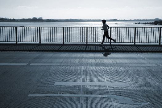 Female jogger passing a bridge. Motion blur.