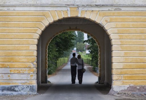 Young couple leaving Valdemar Castle, Denmark through one of the gates.