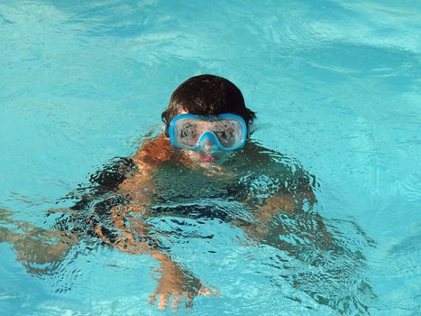 boy with goggles in a swimming pool