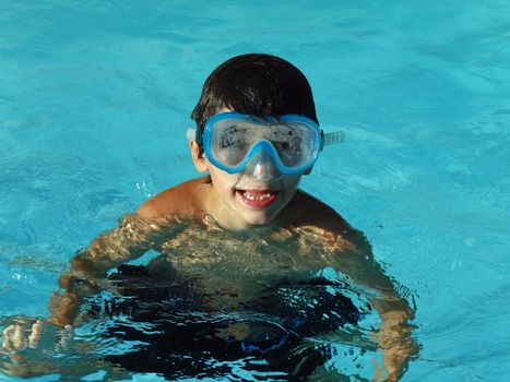 boy with goggles in a swimming pool