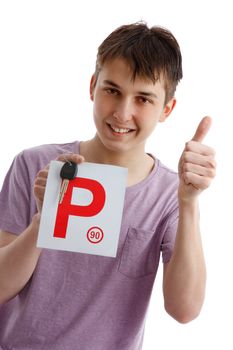 A happy male teen holds a red P plate and car key with thumbs up success sign.  White background.
