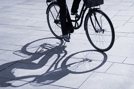 Female riding her bike across an urban square - Denmark.