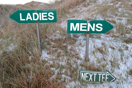 ladies mens and next tee signs on a golf course in winter with ladies on top and mens below