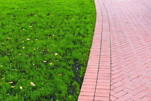 Footpath with green grass on the left, leading a pathway, useful for background leadership and path finding concepts
