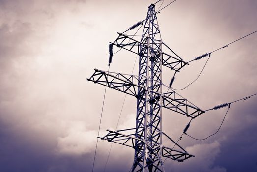 High power electrical pole on a cloudy day with silhouette
