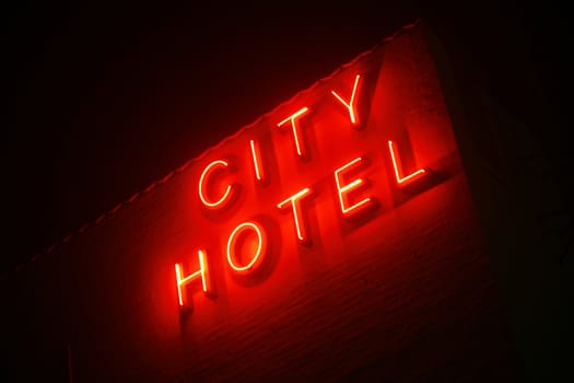 Foggy evening with neon sign saying City Hotel.