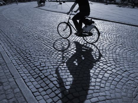  A warm spring afternoon a young man is biking through the old streets of Copenhagen, Denmark.                      