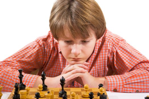 Pensive teenager playing chess in room 