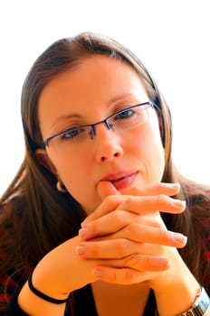 Portrait of a beautiful girl with glasses who clasped her hands and looks straight at the photographer