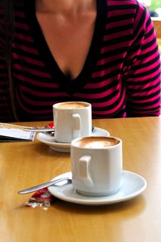   Two cups of cappuccino sfotografiravanny opposite figure women