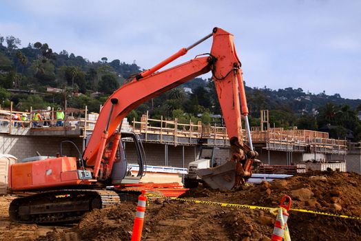 A tracked excavator lowers its bucket on the way to scoop up another load of dirt