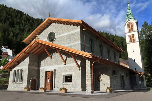 alpine church with wooden roof in Canazei, Trentino, Italy