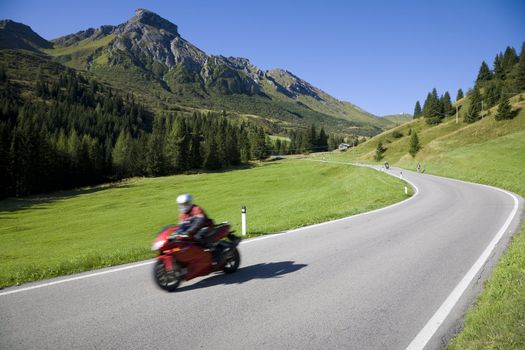 Speedy motorbike on mountain road - Dolomites, Italy.