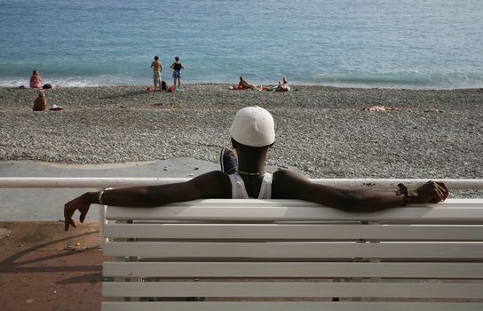 Afro french guy relaxing at the waterfront of Nice - France.