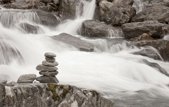 Stacked stones next to a foaming mountain river