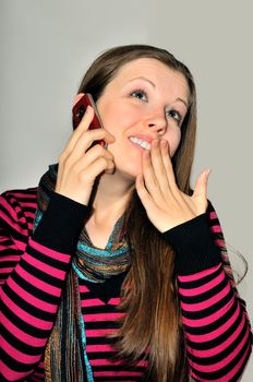 A young girl emotionally expressive talking on a mobile phone