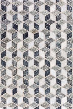 Black and white stone tile mosaic geometric pattern forming 3-dimensional cubes illusion.