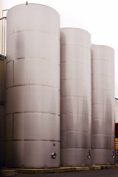 Three stainless steel tanks for storing beverages at bottle filling plant.