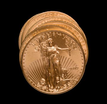Gold Eagle one ounce coins in a stack and isolated against black