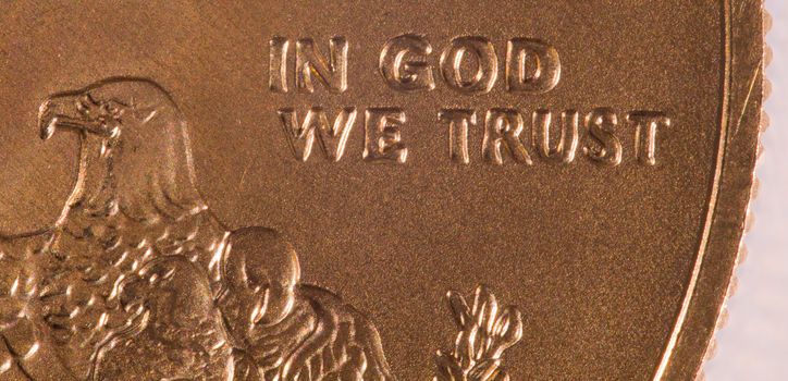 Gold Eagle one ounce coins with macro shot of the engraving of In God We Trust