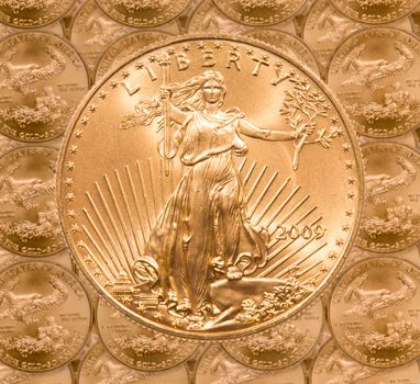 Gold Eagle one ounce coins in a patterns and stacked on each row with a single Liberty coin on the top