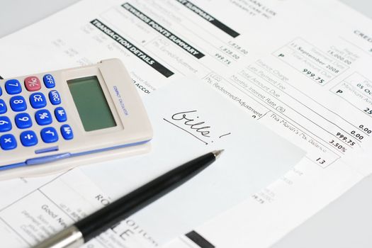 monthly billing statement with pen and calculator
