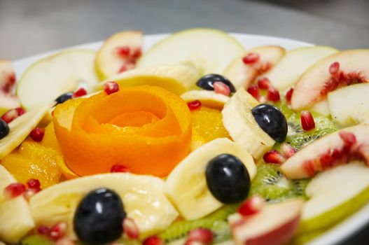 Perfectly designed fresh juicy fruit salad on plate.
Close-up series. Shallow DOF.