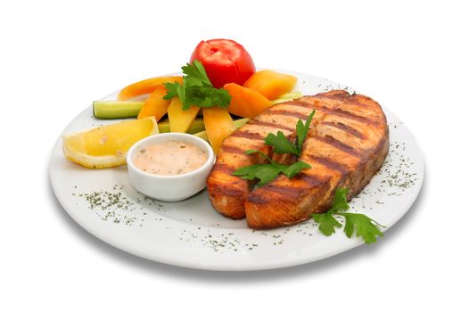 Grilled sturgeon fish with fresh vegetables. served  on the plate with yellow pepper, cucumber and tomato