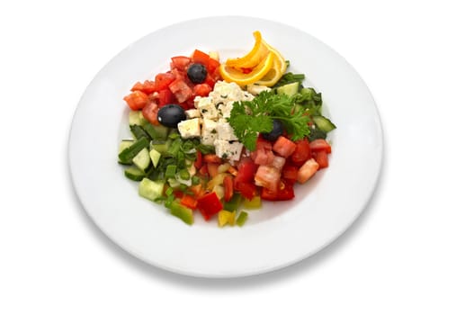 Salad made of fresh tomatoes, feta cheese, cucumbers, red peppers, lemon slices, olives and parsley. 