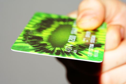 Green credit card close up in a hand