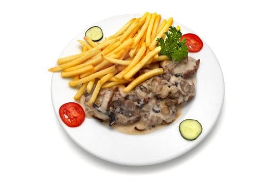 veal medallion with mushroom white sauce and french fries, decorated with parsley, slices of tomato and cucumber