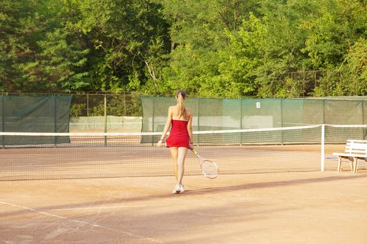 blond girl on the tennis court, rear view