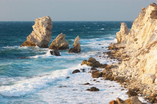 blue sea and rocks storming in light of sunset