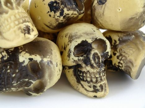 A pile of plastic toy skulls studio isolated over a white background.