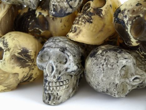 A pile of plastic toy skulls studio isolated over a white background.