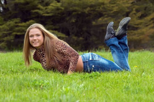 cheerful girl laying on the green grass.