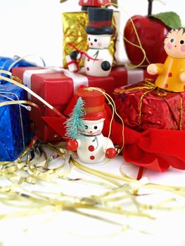 Cute colorful wooden Christmas tree ornaments, displayed with colorful wrapped presents. Over white.