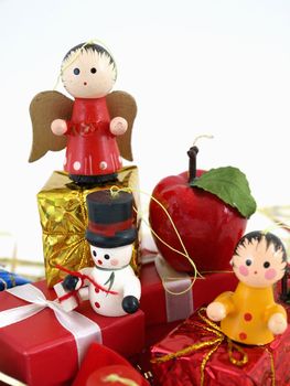 Cute colorful wooden Christmas tree ornaments, displayed with colorful wrapped presents. Over white.