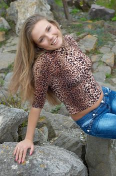 sexy girl with open waist sitting on the stones