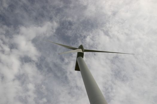 a wind turbine against a calm cloudy sky