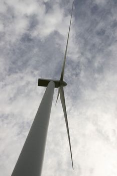 a wind turbine against a calm cloudy sky